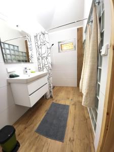 ein Bad mit einem Waschbecken und einem Spiegel in der Unterkunft Villa Agardy 1 in Balatonkenese