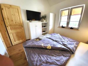 ein Schlafzimmer mit einem Bett mit violetter Bettwäsche und einem Fenster in der Unterkunft Villa Agardy 1 in Balatonkenese