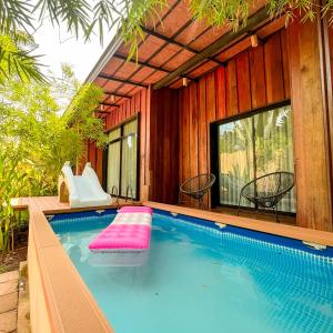 - une piscine avec toboggan dans une maison dans l'établissement บ้านไร่มีสุข Baanrai Meesuk, à Surat Thani