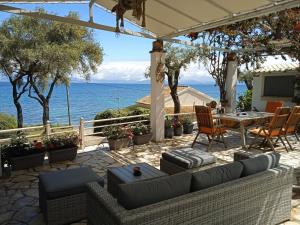 a patio with a table and chairs and the ocean at Sailors Luxury Cottage in Agia Pelagia Chlomou