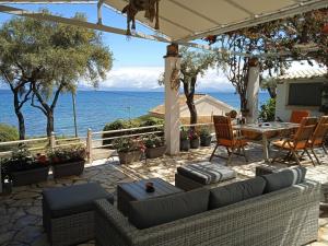 Sailors Luxury Cottage في Agia Pelagia Chlomou: فناء مع طاولة وكراسي والمحيط