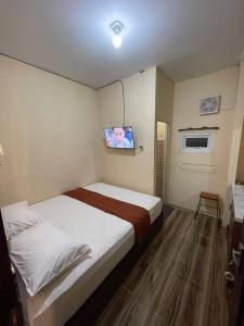 - une chambre avec un lit et une télévision murale dans l'établissement Apartement island, à Jakarta