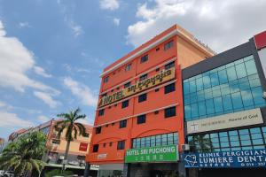 a tall orange building with a sign on it at Hotel Sri Puchong in Puchong