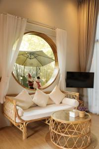 - un salon avec un canapé et un miroir rond dans l'établissement บ้านไร่มีสุข Baanrai Meesuk, à Surat Thani