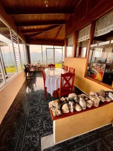 a dining room with a table and chairs and windows at Volcano Views Glampings & Crystal House in Monterrey