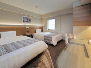 Habitación de hotel con 2 camas y mesa en Keio Presso Inn Otemachi, en Tokio
