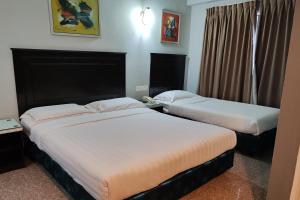 a hotel room with two beds and a window at Hotel Sri Puchong Sdn Bhd in Puchong