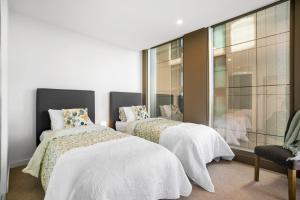 1 dormitorio con 2 camas y ventana en 2BR Apartment in Geelong w/ Spectacular City View en Geelong