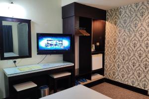 a room with a tv on a shelf with a mirror at Hotel Sri Puchong Sdn Bhd in Puchong
