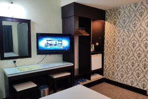 a room with a tv on a shelf with a mirror at Hotel Sri Puchong in Puchong