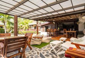 un patio al aire libre con mesas y sillas de madera. en Phatcharee Resort en Baan Tai