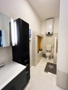a bathroom with a black refrigerator and a toilet at Villa Rapunzel in Brovinje