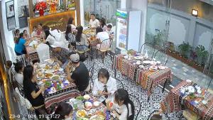 a group of people sitting at tables in a restaurant at Tam Coc Min House in Vũ Lâm