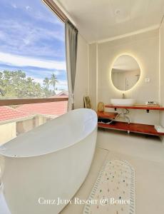 y baño con bañera blanca y espejo. en Chez Judy Resort, en Panglao