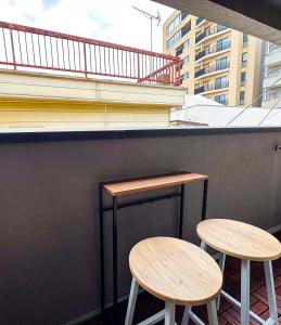 two tables and two stools on the side of a building at Tranquil Tokyo Retreat #Spacious 3BR House in Hiroo in Tokyo