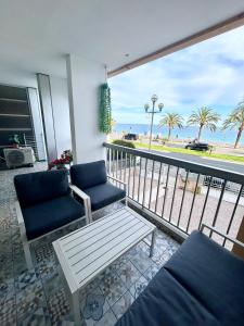 a balcony with two chairs and a table and a view of the beach at Sunny Days in Nice