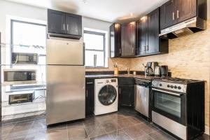 a kitchen with a refrigerator and a dishwasher at 3 Bed Modern Apt in Prime Location in New York