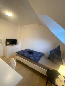 - une petite chambre avec un lit et une télévision dans l'établissement Charmante Wohnungen direkt in der Stadtmitte, à Andernach