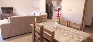 sala de estar con mesa y sofá en Modern Home Accommodation en Zeerust