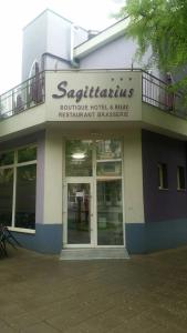 een gebouw met een bord aan de voorkant bij Бутик хотел ресторант брасери Сажитариус in Kyustendil