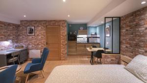 eine Küche und ein Wohnzimmer mit einer Ziegelwand in der Unterkunft L'Atelier Haute Couture in Le Mans
