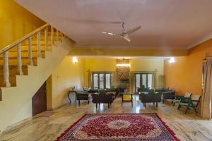 een woonkamer met een trap en een tafel en stoelen bij Anandmai Rohet House Mount Abu in Mount Ābu