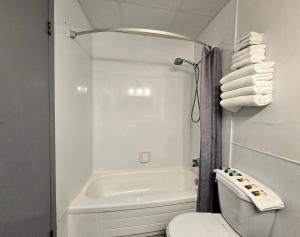 a white bathroom with a tub and a toilet at Alpine Inn in Valemount +43 photos