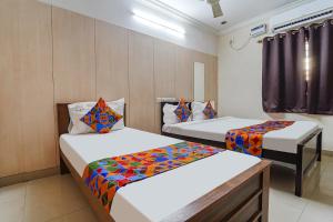 Habitación con 2 camas en una habitación en FabHotel Nest Inn Service Apartment en Chennai