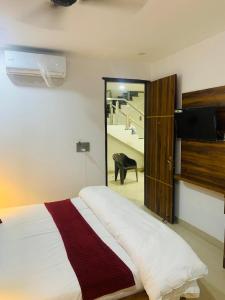 a bedroom with a bed with a television and a staircase at Hotel The Emporio Grand in Ghaziabad