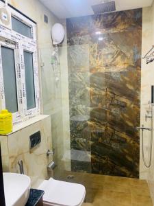 a bathroom with a shower and a toilet at Hotel The Emporio Grand in Ghaziabad