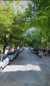 een met bomen omzoomde straat met auto's op straat bij Thessaloniki Amazing Apartment in Thessaloniki