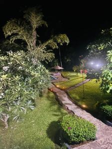 un parque de noche con árboles y un camino en WHITE Nyumba en Malindi