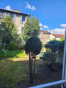 Blick auf einen Garten mit zwei Bäumen und einem Gebäude in der Unterkunft bel appartement in Villeneuve-Saint-Georges
