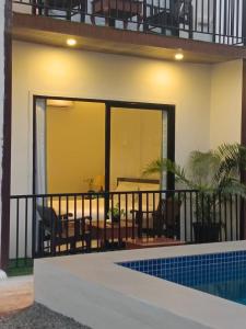 a house with a balcony and a swimming pool at Arambol Sweet Lake Resort in Arambol