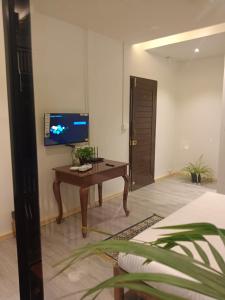 a room with a desk and a tv on a wall at Arambol Sweet Lake Resort in Arambol