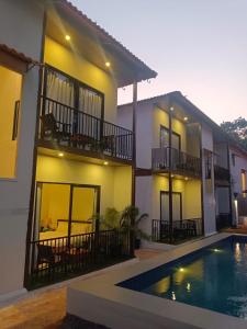 a house with a swimming pool in front of it at Arambol Sweet Lake Resort in Arambol
