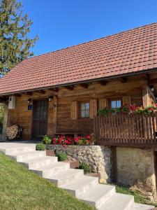 a wooden house with stairs in front of it at Javor Holiday House in Žumberak