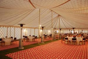 アラハバードにあるShivadya Camps MAHAKUMBH Melaのテーブルと椅子が備わる大型テント