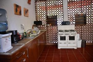 cocina con fogones blancos y encimera en la playita hostal en San José del Cabo