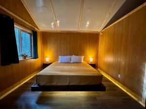 sypialnia z łóżkiem z dwoma lampami po obu stronach w obiekcie Roberts Lodge w mieście Tok