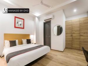 1 dormitorio con 1 cama grande y espejo en Super Townhouse Rohini Sector 23, en Nueva Delhi