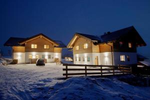 un par de casas en la nieve por la noche en Ski in/Ski out Chalets Tauernlodge by Schladming-Appartements, en Schladming