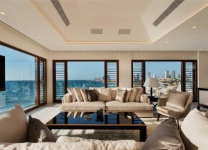 a living room with a couch and some windows at The Setai Tel Aviv, a Member of the leading hotels of the world in Tel Aviv