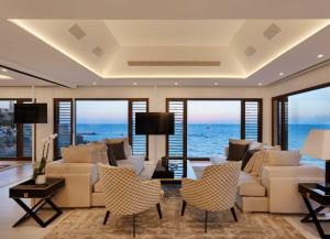 a living room with a couch and chairs and the ocean at The Setai Tel Aviv, a Member of the leading hotels of the world in Tel Aviv