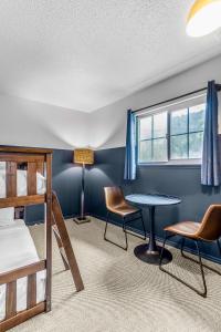 a bedroom with a bed and a table and chairs at The Angler Lodge in Dunsmuir