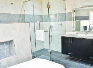 內羅畢的住宿－A PLACE OF TRANQUILITY, Muthaiga，一间带玻璃淋浴和水槽的浴室
