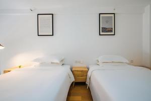 two beds sitting next to each other in a room at Boutique houtel Shanghai Lujiazui in Shanghai