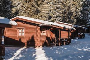 a log cabin with snow on the roof at Villas Jagoda & Malina in Borovets