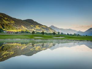 um campo de golfe com um reflexo na água em Luxury chalet in Zillertal em Aschau