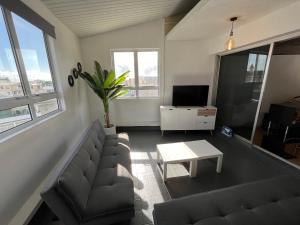 sala de estar con sofá y mesa en Penthouse Happiness, en Papeete